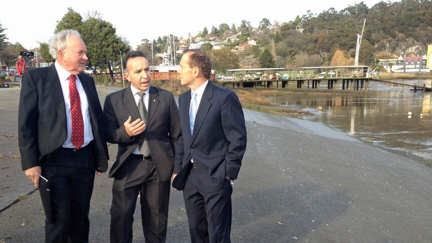 Tony Abbott at the Tamar River with Bass candidate Andrew Nikolik (c) and flood authority's Alan Birchmore (l)