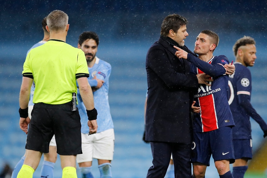 Mauricio Pochettino holds Marco Verratti back, who is angrily pointing at the referee