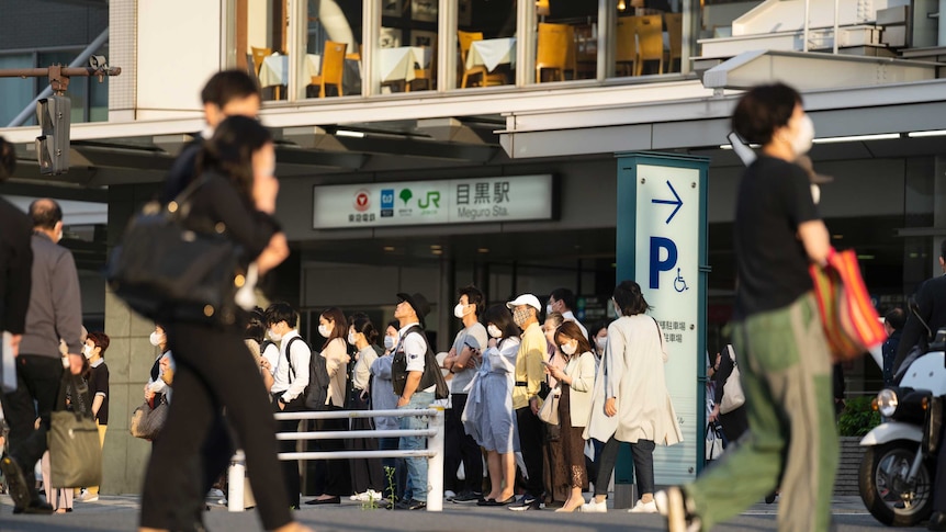 People in face masks walking around Tokyo