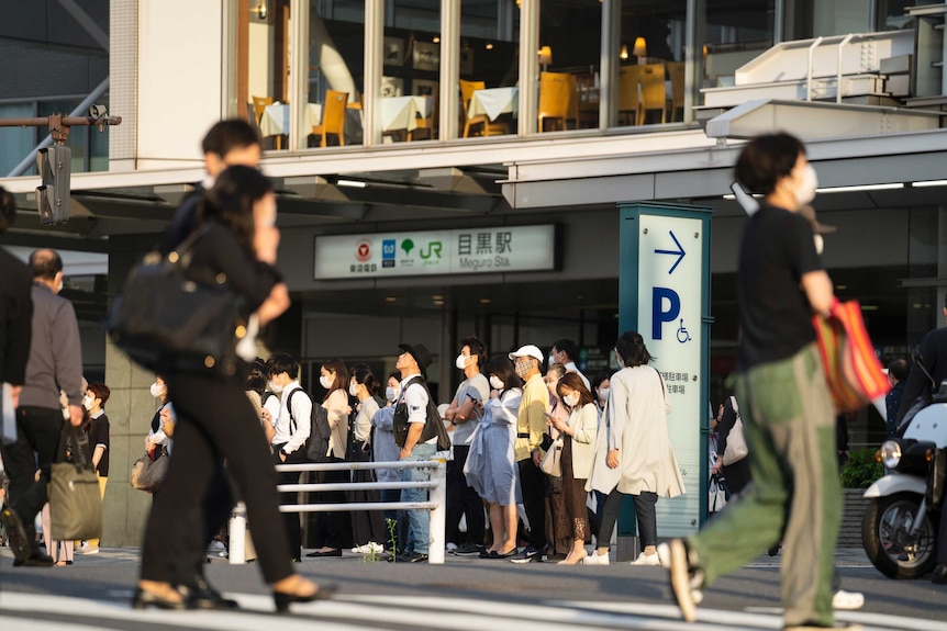 People in face masks walking around Tokyo