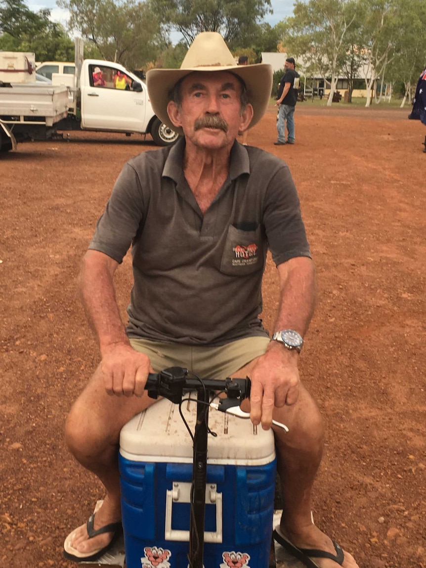 A man sits on a motorised Esky