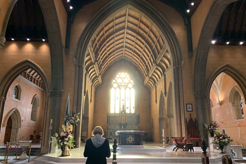 Ferguson in church with stain-glass windows in background.