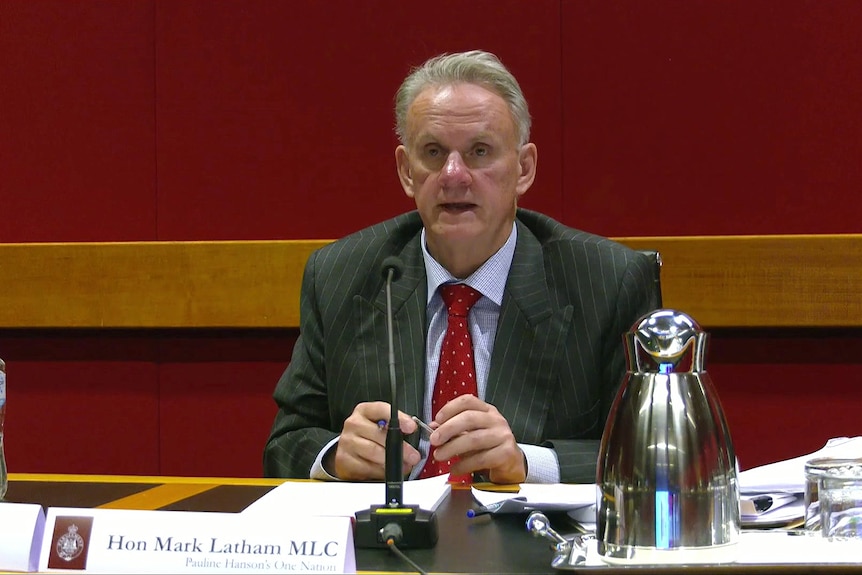 man sitting behind microphone at desk