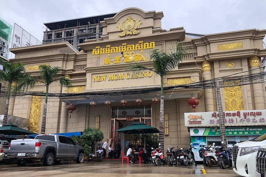 A building surrounded by palm trees with a gold sign reading "News MGM Casino"