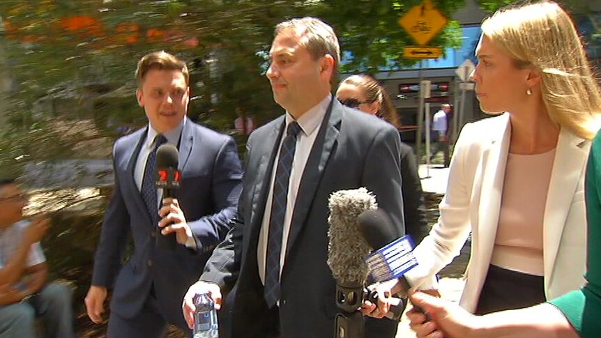 Clive Palmer's brother-in-law Goerge Sokolov walking out of the Federal court with reporters next to him.
