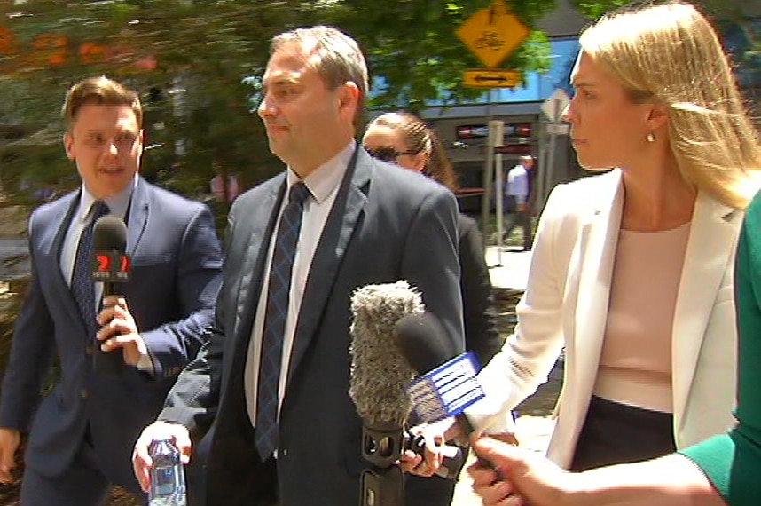 Clive Palmer's brother-in-law Goerge Sokolov walking out of the Federal court with reporters next to him.