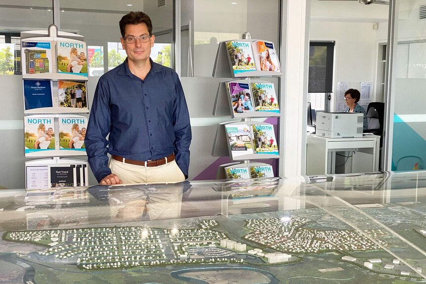 Brian Finnrey stands in front of a model of the North Harbour residential and marina development