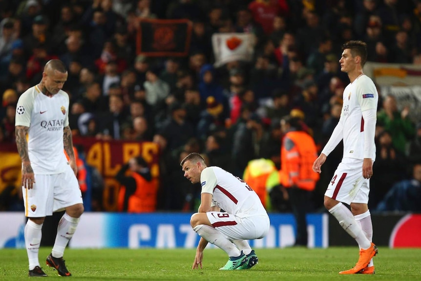 Roma's Edin Dzeko, center, reacts, defeated, at the end of the Champions League semifinal