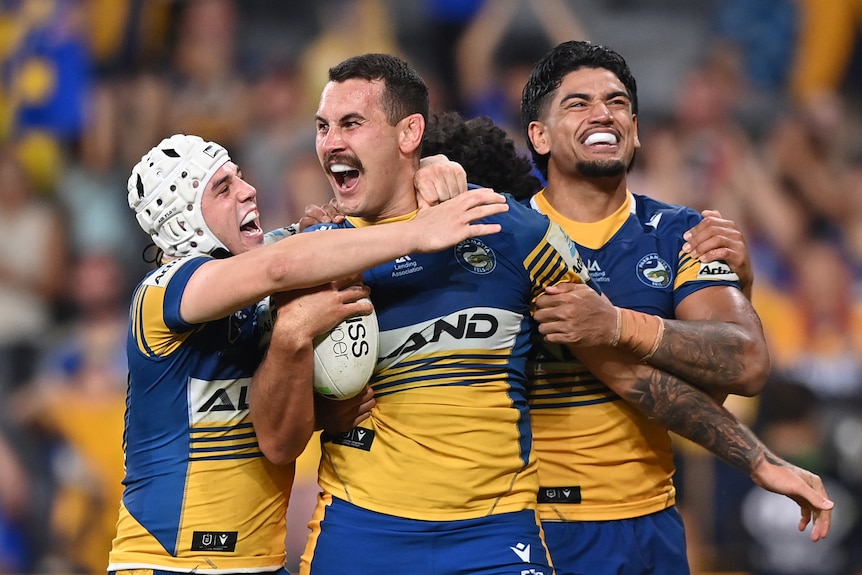 Four Parramatta Eels NRL players celebrate a try against the Sharks.