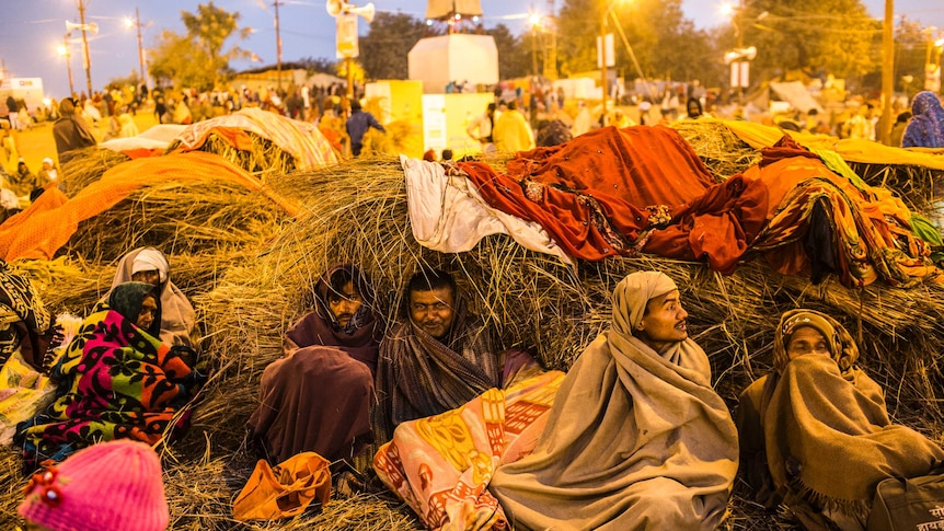 Hindu devotees warm themselves in the early morning before taking a bath on the banks of Sangam during the Kumbh Mela festival.