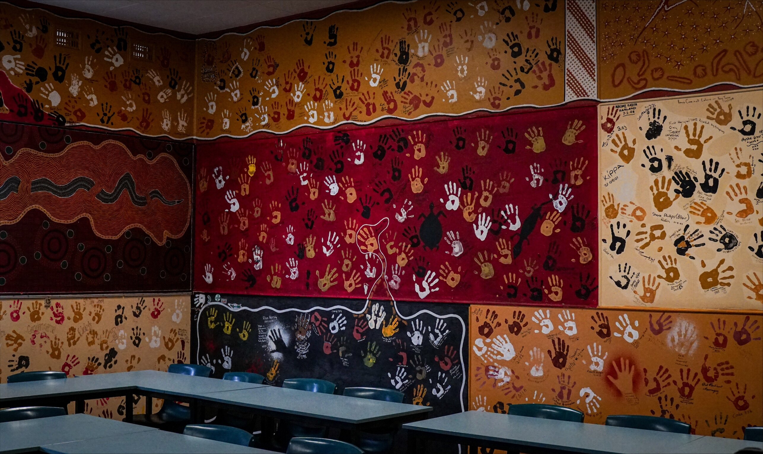 A room with walls covered in painted handprints.