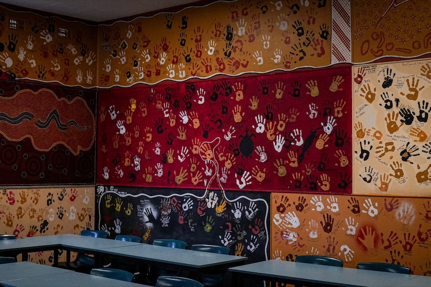 A room with walls covered in painted handprints.