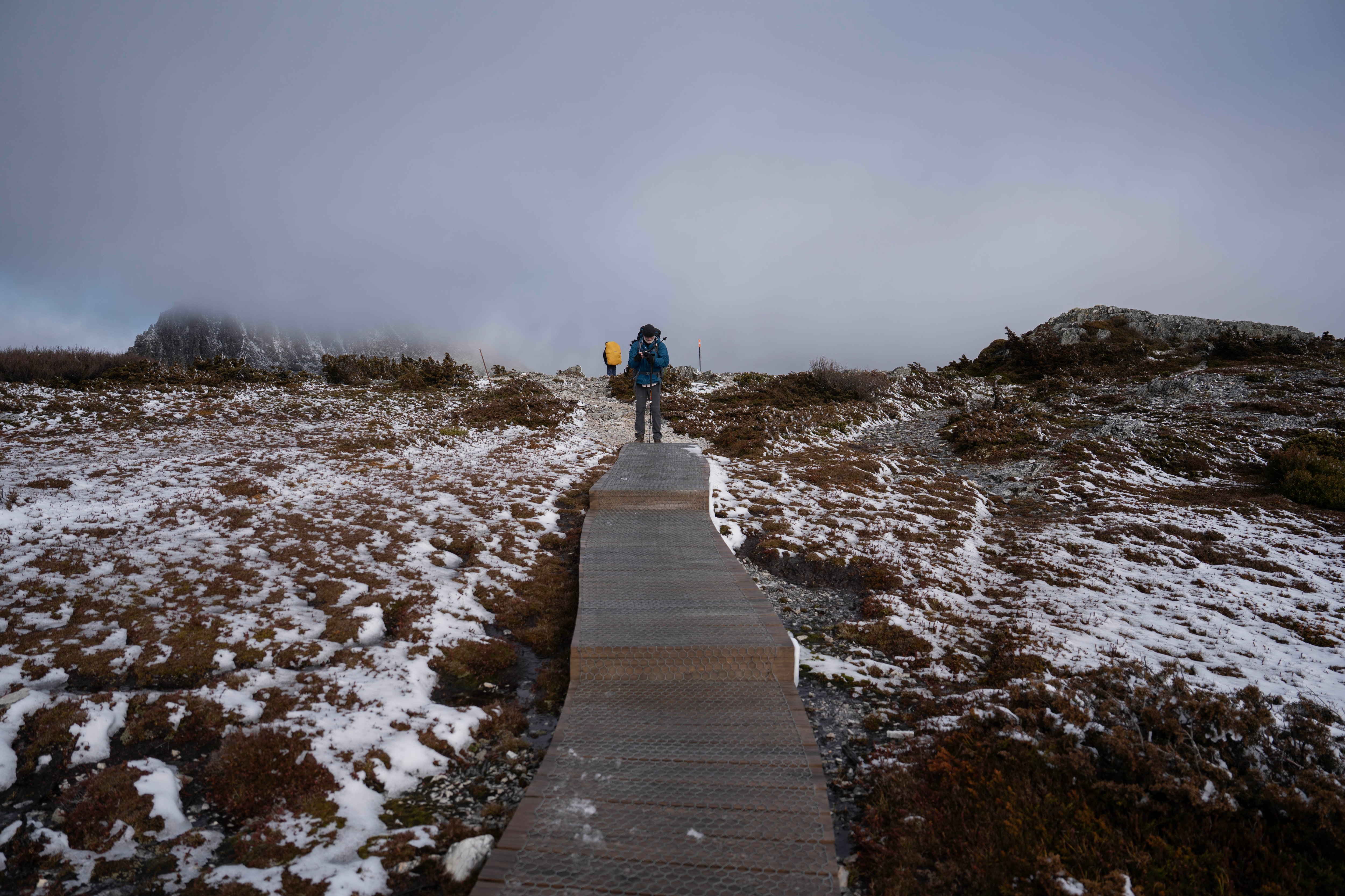 A hiker on a snowy boardwalk.