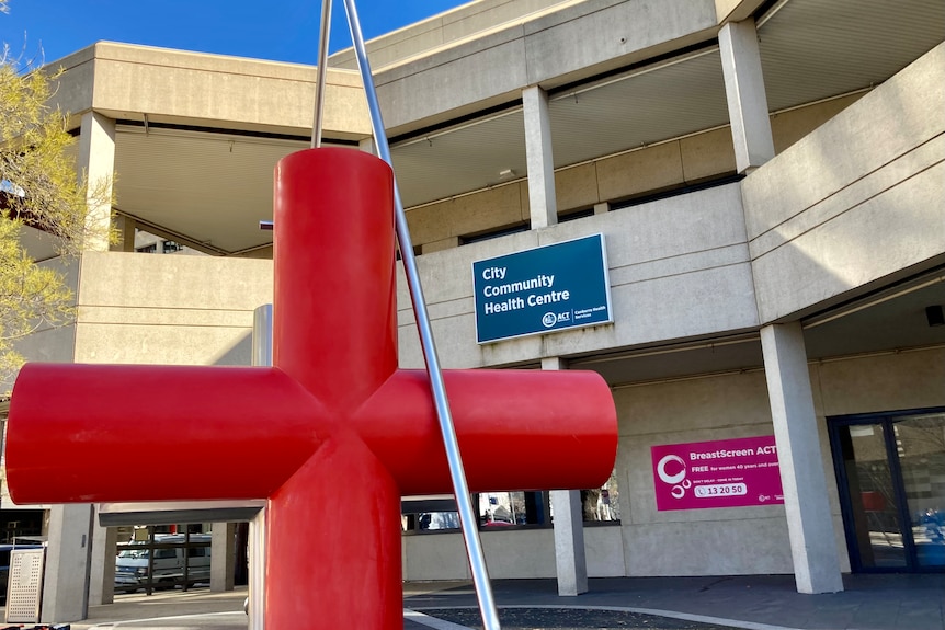 An exterior of a Canberra building with a big red cross.
