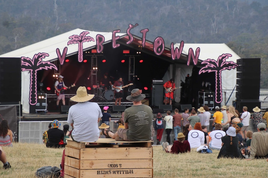 festival goers sitting on hay bales near the Vibestown stage at Party in the Paddock 2020