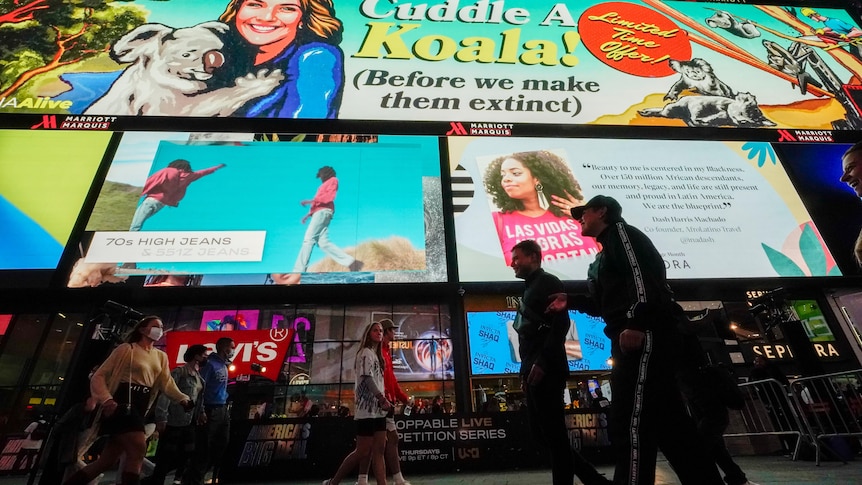 A billboard ad says "Cuddle a Koala before we make them extinct