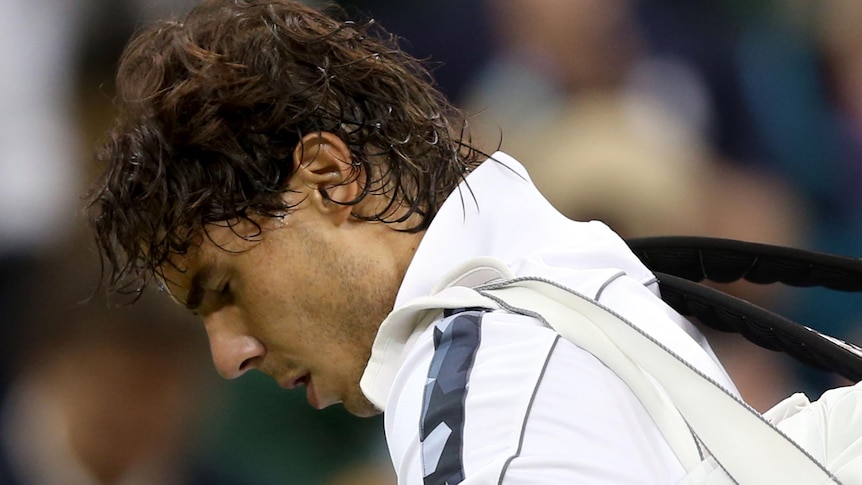 Rafael Nadal walks off the court after his surprise loss at Wimbledon.