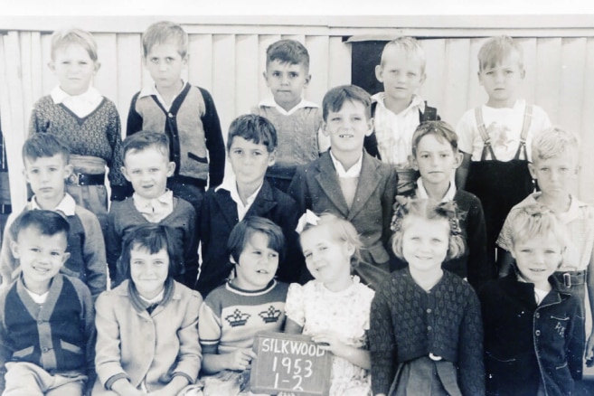 A black and white primary school class photo of 18 children, including Darryl Low Choy, seated in the front row on the left.