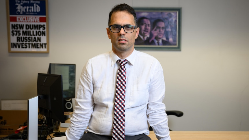 NSW Treasurer Daniel Mookhey stands in front of his desk posing for a potograph