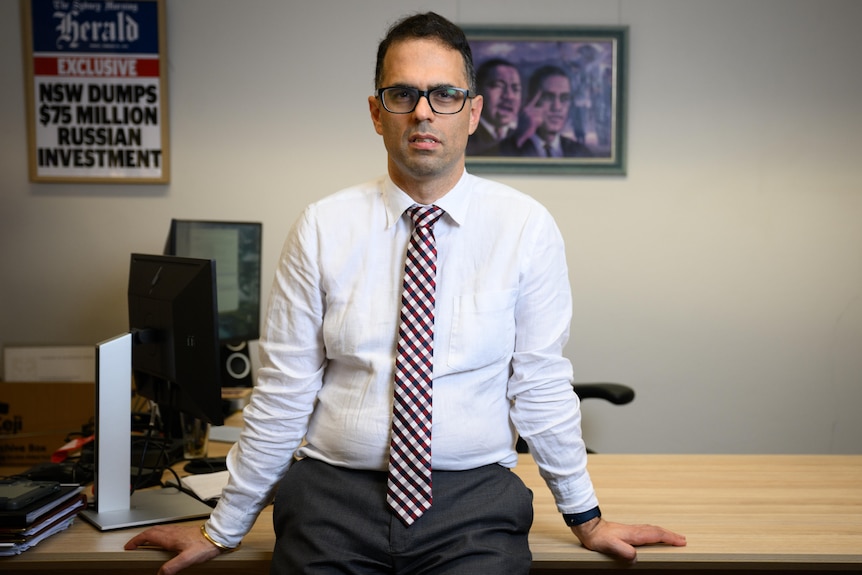 NSW Treasurer Daniel Mookhey stands in front of his desk posing for a potograph
