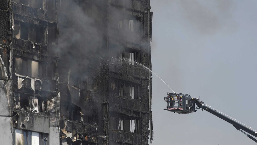 Firefighters direct jets of water onto a tower block severely damaged by serious fire in North Kensington.