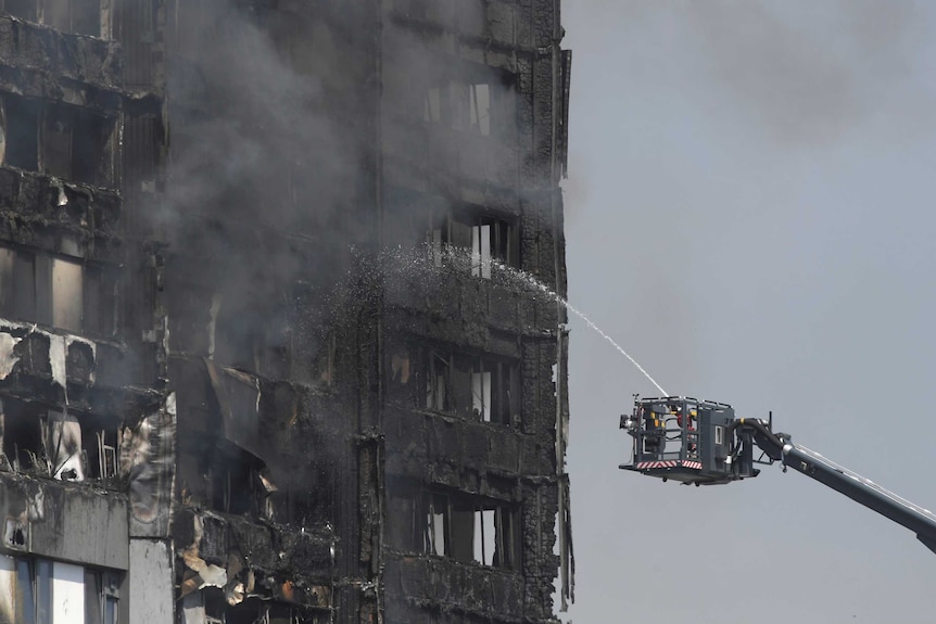 Firefighters direct jets of water onto a tower block severely damaged by serious fire in North Kensington.