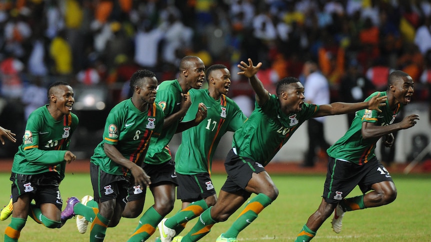 Win on penalties ... Zambian players rush the pitch in celebration after winning the final in a shoot-out.
