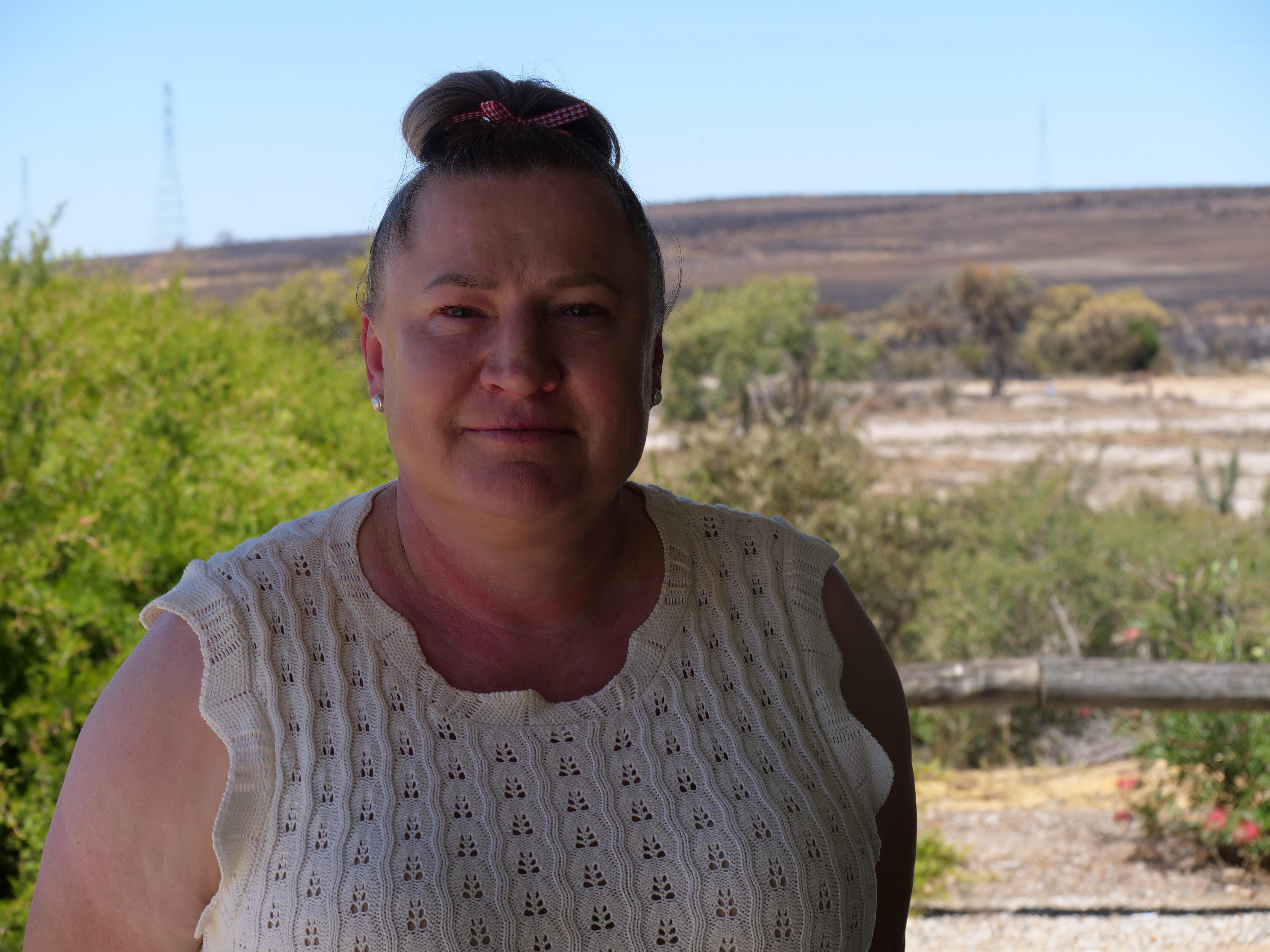 Retrato de mulher na frente de arbustos queimados