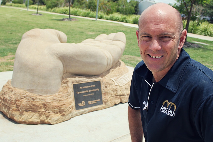 Stonemason Daniel Gill in front of the sculpture