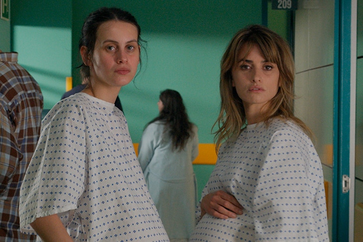 Two heavily pregnant women stand together in the hallway of a maternity ward - one is a teenager, while the other is in her 40s