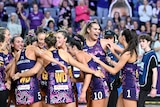 Queensland Firebirds players smile and hug each other