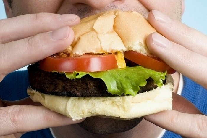 A man biting into a hamburger