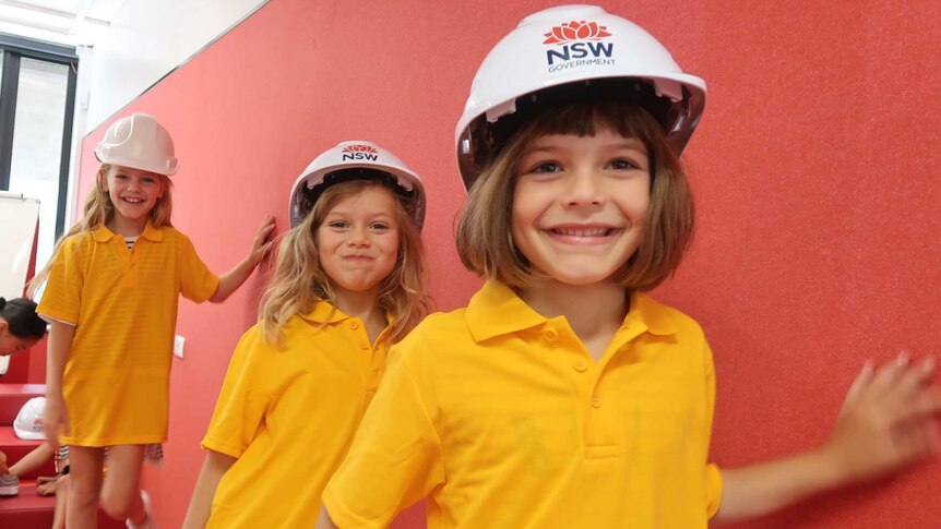 Three girls wear helmets