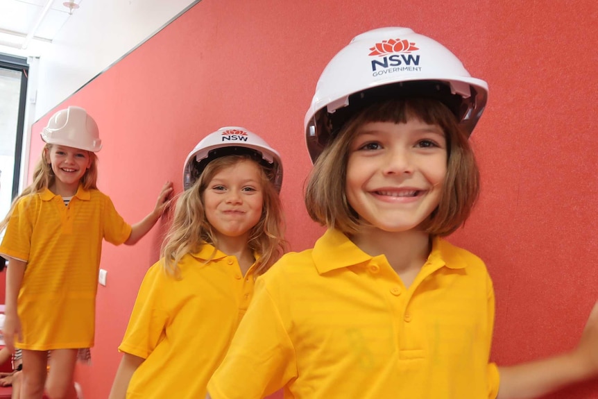 Three girls wear helmets