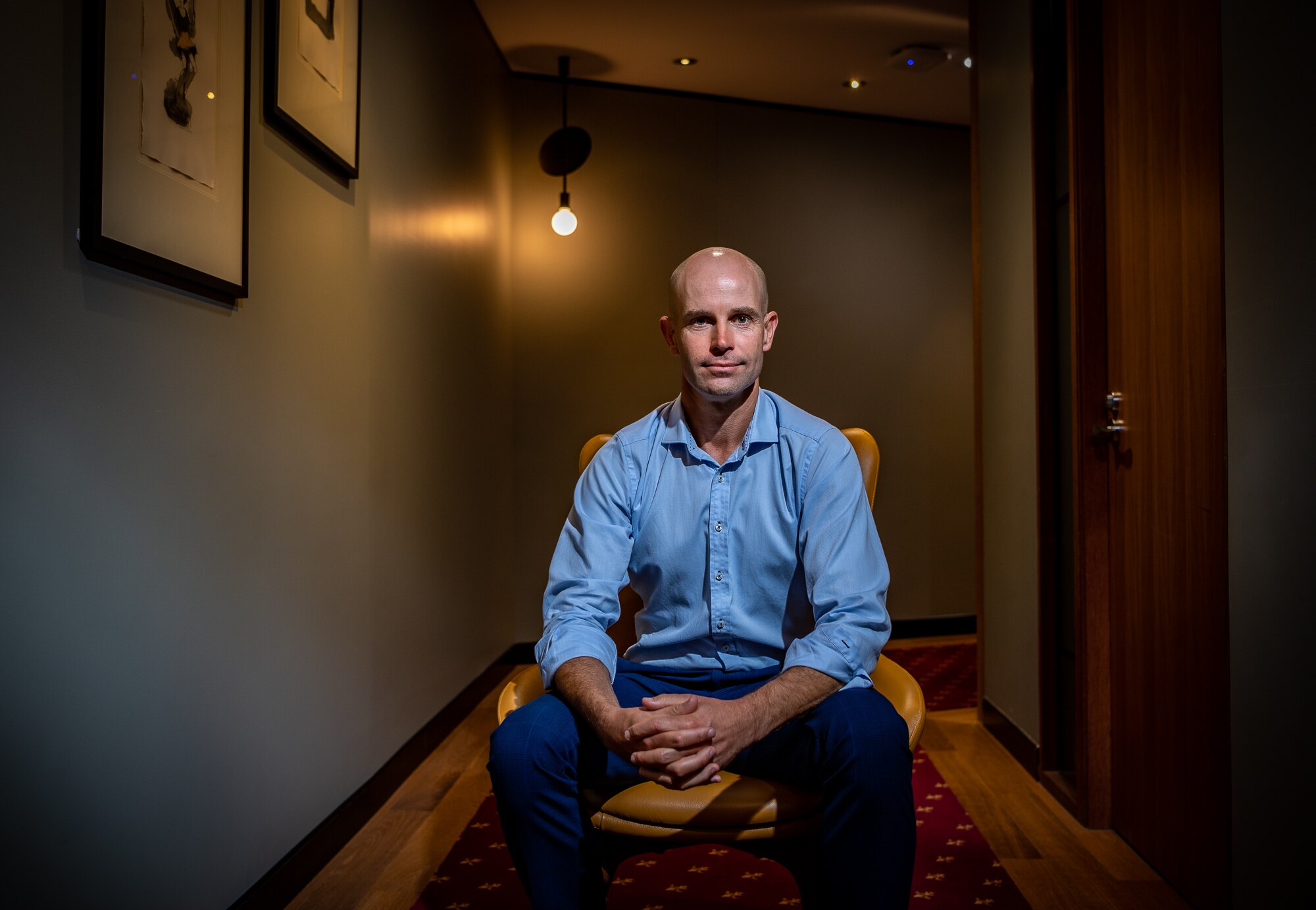 A man in a boardroom setting with a light in the background.
