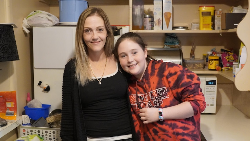 Leanne Taylor and her 11-year-old daughter Claudia hug in the kitchen. 