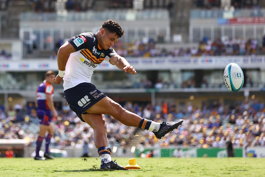 The ball leaves the tee as Noah Lolesio of the Brumbies kicks for goal in the Super Rugby.