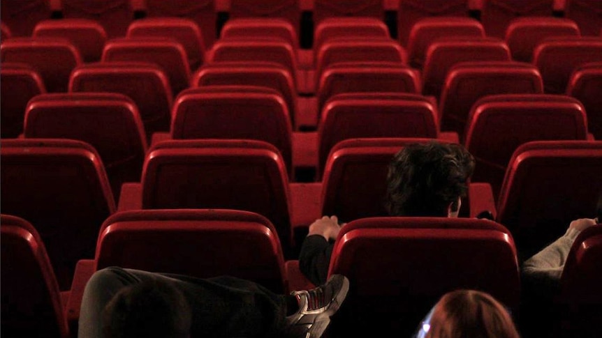 People watch a movie in a mostly empty cinema