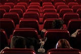 People watch a movie in a mostly empty cinema