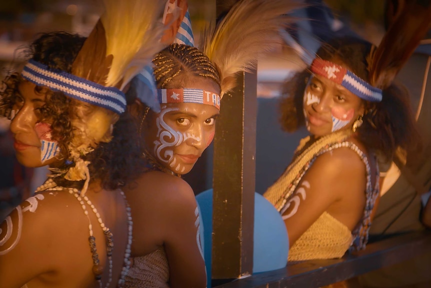 Three women who are supporters of West Papuan independence are dressed in traditional clothing and paint.