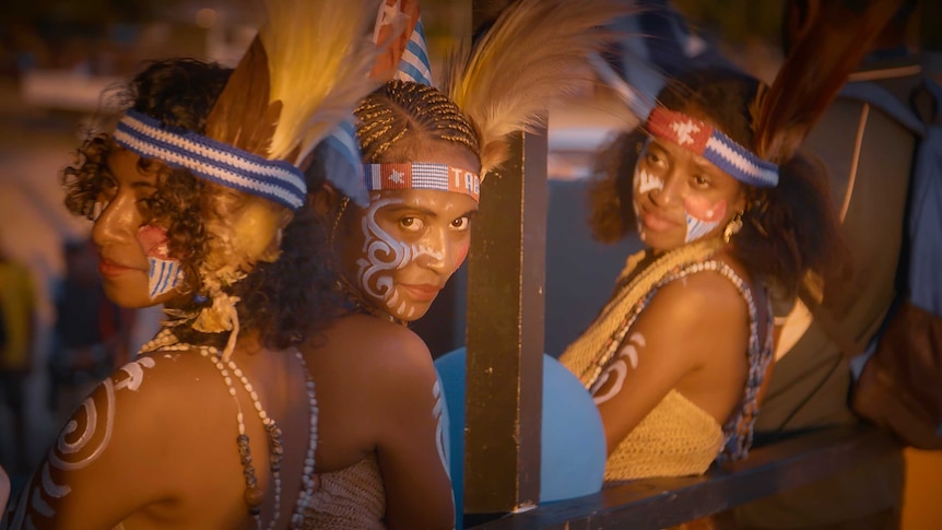 Three women who are supporters of West Papuan independence are dressed in traditional clothing and paint.