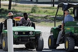 Two green vehicles with staff from Christian Aid Ministries pass each other by.