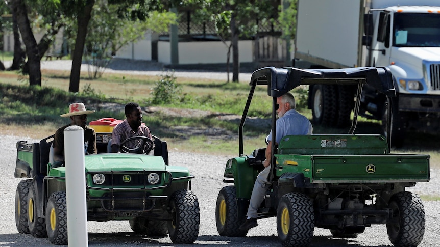 Two green vehicles with staff from Christian Aid Ministries pass each other by.