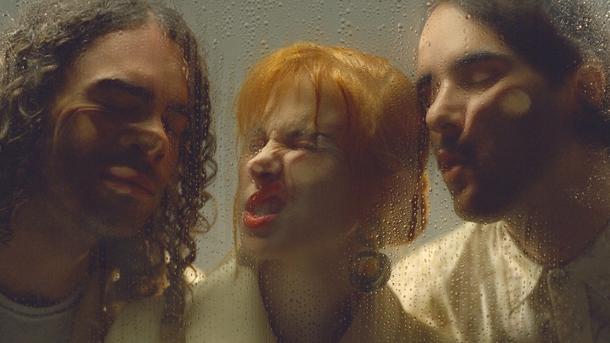 Paramore with their faces pressed up against wet, foggy glass