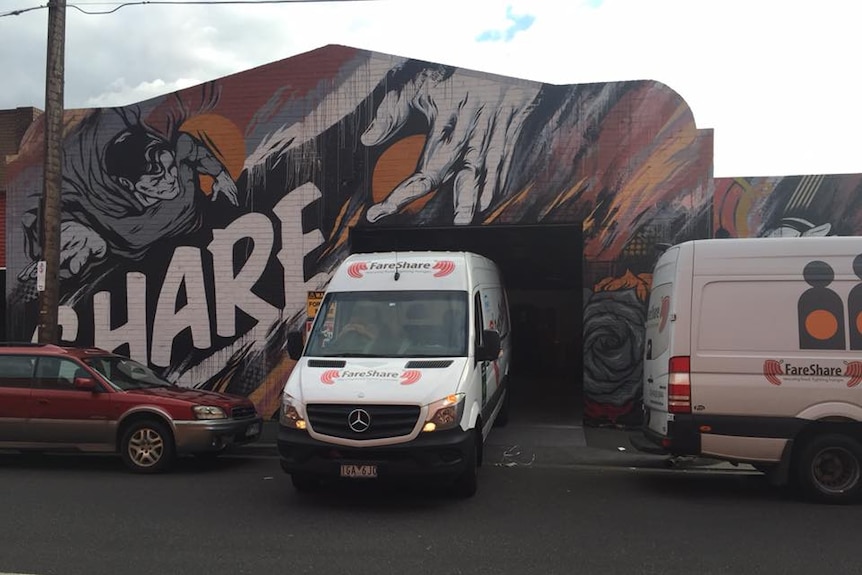 Food truck drives out of a factory covered in street art.