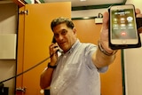 A man demonstrating how a satellite phone works from landline to mobile.