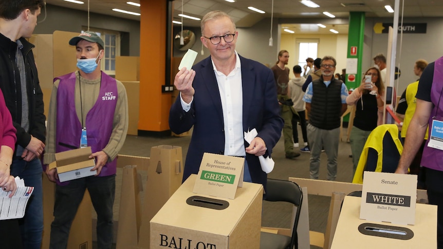 Anthony Albanese holds up his ballot while voting in the election that makes him the prime minister