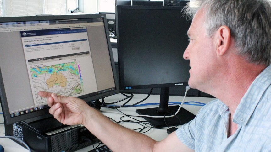Man points to a computer model illustrating weather patterns.