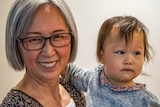 A close up picture of a smiling grandmother and her granddaughter
