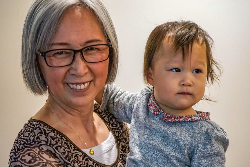 A close up picture of a smiling grandmother and her granddaughter